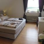 Schlafzimmer mit Doppelbett, Holzboden und Fenster mit Blick auf Feld.