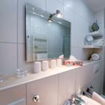 Badezimmer mit Spiegel, Dusche und Handtuchhalter