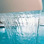Wasser fällt aus einer Wand in den Pool.