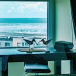 Tisch mit Vogeldekoration vor Meerblick aus Fenster
