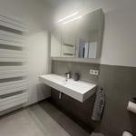 Badezimmer mit Waschbecken, Spiegel und Heizkörper