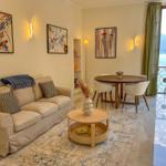 Living and dining area with sofa, table, and balcony view of water.