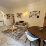 Living and dining area with sofa, dining table, and modern kitchen.