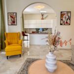 Living area with yellow seating and view into the kitchen.