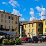 Town center with yellow buildings, streets, and parking spots under blue sky.