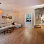 Wohnzimmer mit Sofa, Treppenhaus und TV. Durchgang zum Schlafzimmer.