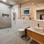 Bad mit Dusche, Waschbecken und Toilette. Wandgestaltung und Beleuchtung.