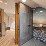 Dusche mit Strandmotivwand, Holzstütze und moderner Duscheinrichtung.