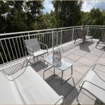 Terrasse mit Gartenmöbeln und Blick auf Bäume.