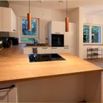 Moderne Küche mit Holzinsel und grünem Fliesenwand