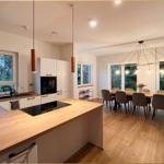 Küche mit Essbereich, Holzoberflächen und moderner Beleuchtung.