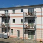 Ferienwohnung mit Balkonen und Terrassen. Modernes Gebäude mit Fenstern und Türen.