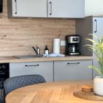 Küche mit Arbeitsfläche, Spüle, Kaffeemaschine und Pflanze auf Tisch