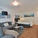 Schlafzimmer mit Sofa, Bett und Wandbildern