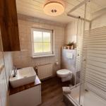 Badezimmer mit Dusche, Toilette und Waschbecken.