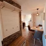 Essbereich mit Tisch und Stühlen, Schlafzimmer mit Schiebetür und Holzboden