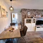 Essbereich mit Tisch und Stühlen. Wohnbereich mit Fernseher und Stehlampe.