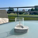 Auf der Terrasse steht ein Glas mit Anker auf einem Sockel mit der Aufschrift MEERZEIT.