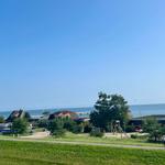 Meerblick mit Strandpromenade und Spielplatz im Vordergrund.