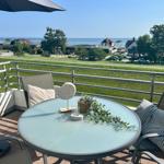 Terrasse mit Tisch, Stühlen und Blick aufs Meer