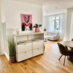 Wohnung mit Essbereich, Wohnzimmer und Schlafzimmer. Holzboden und helles Interieur.