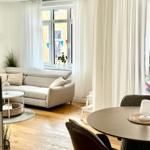 Wohn- und Essbereich mit Sofa, Tisch und Fenster.