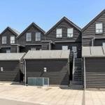 Reihe moderner Holzhauser mit Garagen und Außentreppe.