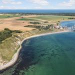 Hafen mit Booten an Küste mit Feldern und Wald