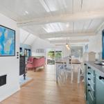 Küche mit Essbereich und Wohnbereich mit Holzboden und weißen Deckenbalken.