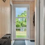 Eingangsbereich mit Holzwand und Tür zum Garten.