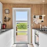 Küche mit Holzwand, Tür zum Garten und Küchengeräten.