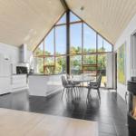 Moderne Küche mit Essbereich und Kamin unter hohem Holzdach