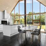 Moderne Küche mit Essbereich und großem Fensterblick auf Garten.