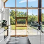 Moderne Küche mit großem Fenster und Blick auf den Garten.