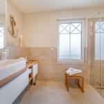 Badezimmer mit Dusche, Waschbecken und Fenster mit Blick.