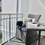 Terrasse mit Stuhl, Tisch und Blick auf Garten und Häuser.