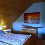 Schlafzimmer mit Bett, Nachttisch und Schrank. Decke mit Sternen, Wandbild und Holzdekoration.