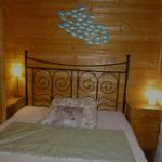 Schlafzimmer mit Holzwand, Metallbett und Fischdekoration.