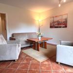 Wohnzimmer mit Sofa, zwei Sesseln und Tisch auf Teppich