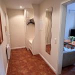 Flur mit Kleiderschrank und Spiegel, Blick in Wohnzimmer mit Sofa und TV.