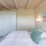 Schlafzimmer mit Bett, Kleiderschrank und Wandbild