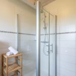 Dusche mit Glaswand, Handtuchständer und Heizkörper