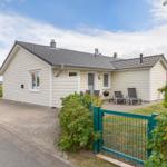Wohnhaus mit Terrasse, Grill und Gartenzaun. Hinterhof mit Sitzgelegenheiten.
