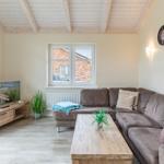 Wohnzimmer mit Sofa, Couchtisch und Fernseher. Holzdecke und Fenster mit Blick.