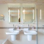 Badezimmer mit zwei Waschbecken, Dusche und Badewanne.