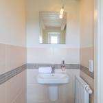 Badezimmer mit Waschbecken, Spiegel und Heizkörper