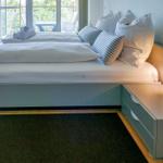 Schlafzimmer mit Doppelbett, Nachttisch und Balkonansicht.