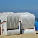 Zwei weiße Strandkörbe stehen am Strand von Cuxhaven.