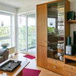 Wohnzimmer mit Sofa, Glaswand, TV und Holzmöbel