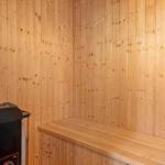 Sauna mit Holzwand und Sitzbank sowie Heizung.